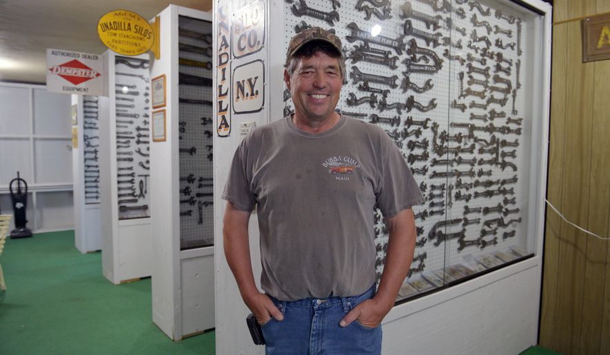 In this Aug. 2, 2017 photo, Russell Marshall poses with some of his wrenches that are on display at the Graves Public Library in Wakefield, Neb. Russell Marshall isn't sure his collection is worth all that much, but he said he has no plans to get rid of it. His collection? More than 3,000 antique wrenches. (Darrin Epperly/The Norfolk Daily News via AP)