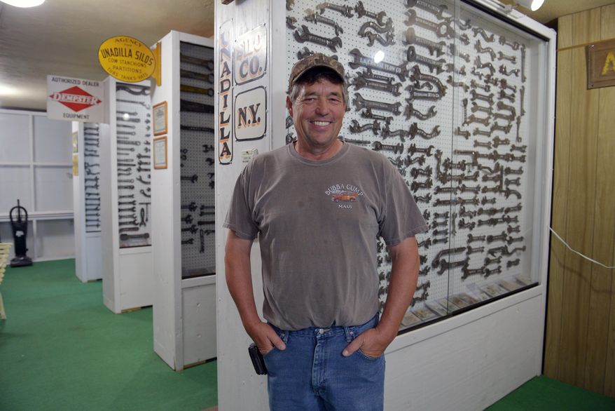 In this Aug. 2, 2017 photo, Russell Marshall poses with some of his wrenches that are on display at the Graves Public Library in Wakefield, Neb. Russell Marshall isn't sure his collection is worth all that much, but he said he has no plans to get rid of it. His collection? More than 3,000 antique wrenches. (Darrin Epperly/The Norfolk Daily News via AP)