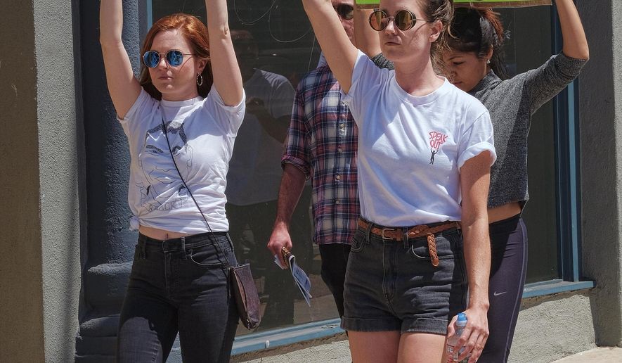 Demonstrators carrying signs walk along Main Street in the Venice beach area of Los Angeles on Saturday, Aug. 19, 2017. Hundreds of people rallied in Southern California to condemn racism in the wake of the deadly events in Charlottesville, Va. (AP Photo/Richard Vogel)