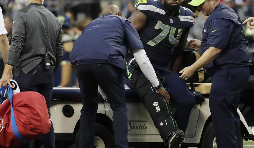 Seattle Seahawks offensive tackle George Fant is helped onto a cart after he went down on a play against the Minnesota Vikings during the first half of an NFL football preseason game, Friday, Aug. 18, 2017, in Seattle. (AP Photo/Stephen Brashear)
