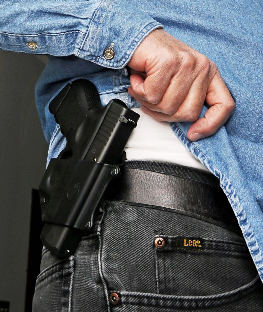 In this 2013 file photo a man displays his holstered sidearm. The AP reported on April 12, 2018, that a California teacher who accidentally discharged his gun in class has tendered his resignation, effective at the end of the school year. (Associated Press)