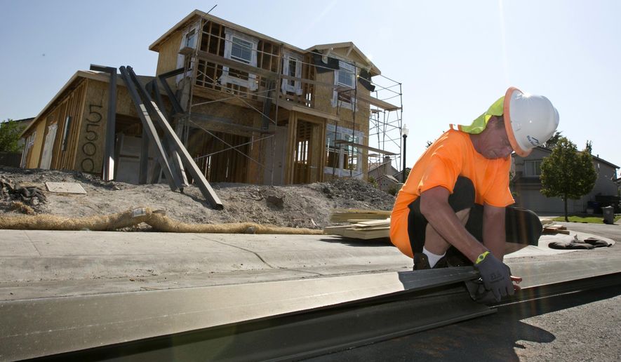 In this photo taken Wednesday, Aug. 16, 2017, sheet metal worker Benjamin Voget prepares to install a gutter on a home under construction in Sacramento, Calif. Gov. Jerry Brown and Democratic legislative leaders promised to tackle California's housing crisis in the final weeks of the legislative session by pushing a package that includes money for low-income housing and regulatory reforms. Lawmakers say the housing shortage is affecting people throughout the state at nearly all income levels. (AP Photo/Rich Pedroncelli)