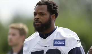 In this June 13, 2017, file photo, Seattle Seahawks defensive end Michael Bennett walks off the field following NFL football practice in Renton, Wash. Bennett said he will sit during the national anthem this season to protest social injustice and segregation. (AP Photo/Ted S. Warren) ** FILE **