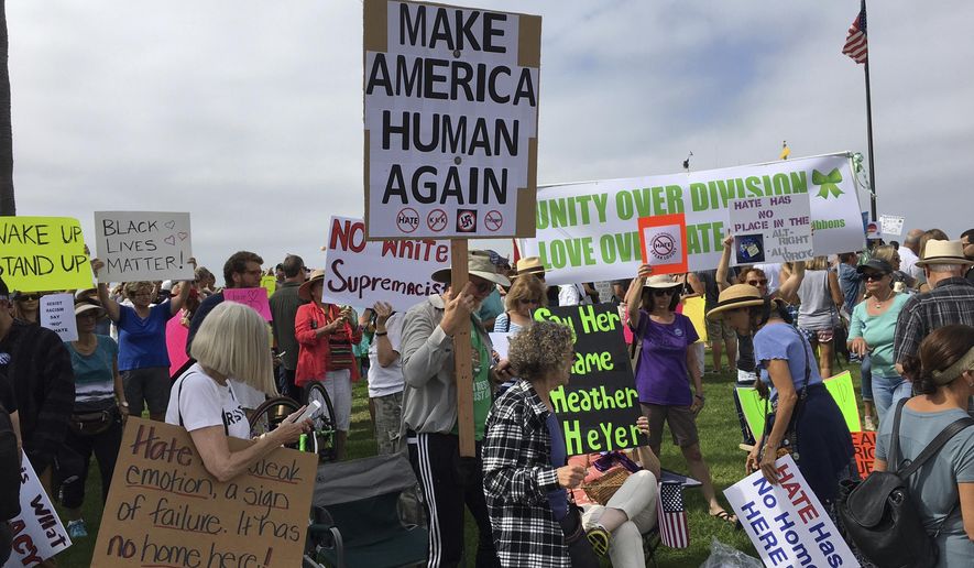 People participate in an anti-racism rally in Laguna Beach, Calif., Saturday, Aug. 19, 2017. Hundreds of people rallied at Southern California beaches to condemn racism in the wake of the deadly events in Charlottesville, Va. (Mark G. Davis via AP)