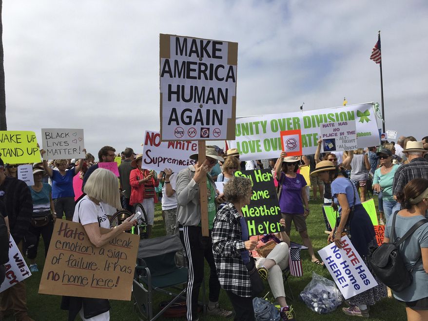 People participate in an anti-racism rally in Laguna Beach, Calif., Saturday, Aug. 19, 2017. Hundreds of people rallied at Southern California beaches to condemn racism in the wake of the deadly events in Charlottesville, Va. (Mark G. Davis via AP)