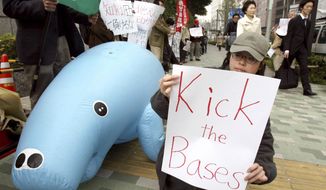 FILE - In this April 8, 2006 file photo, protesters stage a rally with an inflatable doll of dugong opposing the U.S. military base relocation in Okinawa, outside Japan&#39;s defense agency in Tokyo. A federal appeals court has revived a lawsuit Monday Aug. 21, 2017, that seeks to block construction of a U.S. military base in Okinawa, Japan. The suit by the Center for Biological Diversity argues that U.S. officials failed to adequately consider the base&#39;s effects on the Okinawa dugong, an endangered marine mammal that resembles a manatee. (AP Photo/Shuji Kajiyama, File)