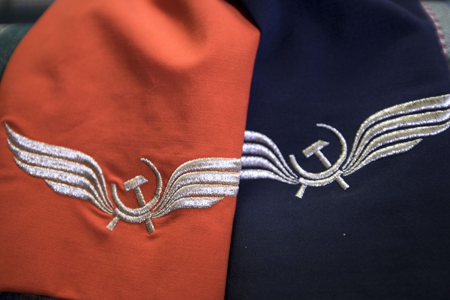 In this photo taken on Thursday, Aug. 3, 2017, Aeroflot flight attendant Yevgeniya Magurina shows her summer and winter uniforms at her home in Lobnya, outside Moscow, Russia. The Moscow City Court is to due to rule in the case of two flight attendants who are suing Russia's flagship airline for taking them off the prestigious long-haul flights because of their looks. (AP Photo/Alexander Zemlianichenko)