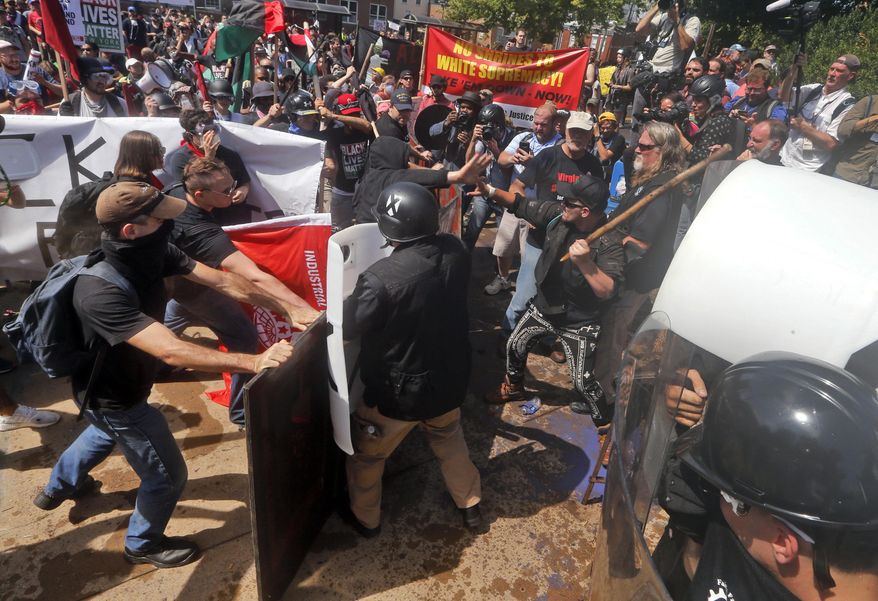  In this Aug. 12, 2017 file photo, white nationalist demonstrators clash with counter demonstrators at the entrance to Lee Park in Charlottesville, Va. (AP Photo/Steve Helber, File) **FILE**