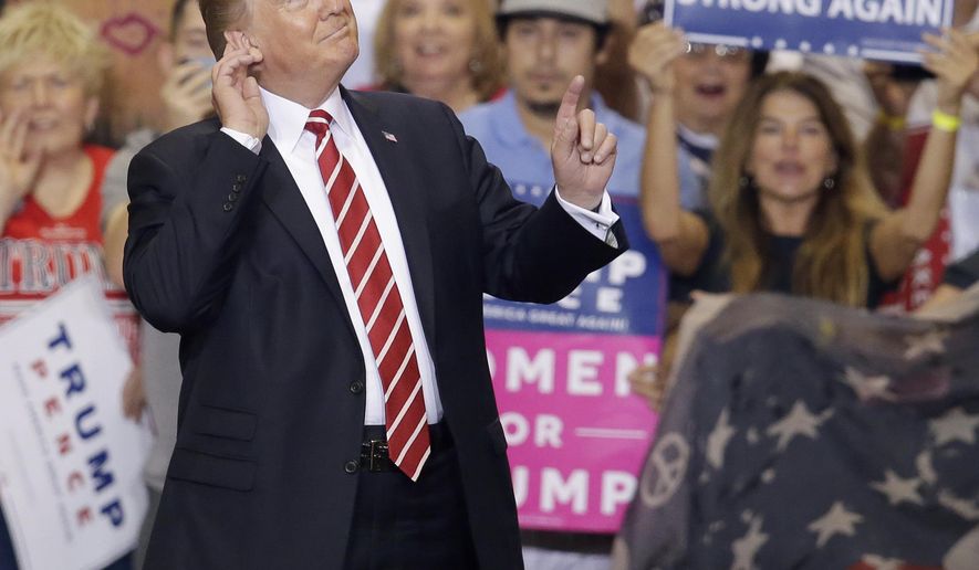 President Donald Trump gestures to the crowd while speaking at a rally at the Phoenix Convention Center, Tuesday, Aug. 22, 2017, in Phoenix. (AP Photo/Rick Scuteri)