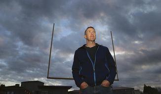 In this Nov. 5, 2015, photo, former Bremerton High School assistant football coach Joe Kennedy poses for a photo at Bremerton Memorial Stadium in Bremerton, Wash. A federal appeals court ruled Wednesday, Aug. 23, 2017, that the Bremerton School District does not have to immediately re-hire Kennedy, who lost his job after refusing to stop leading players in prayer on the football field after games. (Larry Steagall/Kitsap Sun via AP) **FILE**