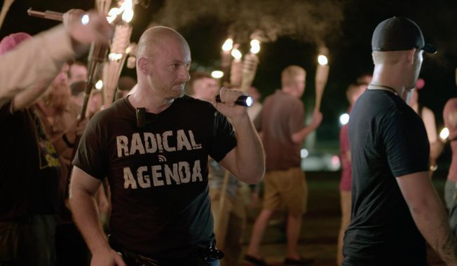 In this Friday, Aug. 11, 2017, file image made from a video provided by Vice News Tonight, Christopher Cantwell attends a white nationalist rally in Charlottesville, Va. On Wednesday, Aug. 23, Cantwell, a white nationalist, turned himself in to face three felony charges in Virginia, authorities said. Cantwell was wanted by University of Virginia police on two counts of the illegal use of tear gas or other gases and one count of malicious bodily injury with a &amp;quot;caustic substance,&amp;quot; explosive or fire. (Vice News Tonight via AP, File)