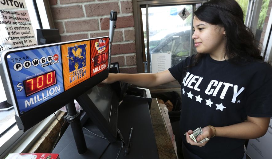 Anahi Medrano sells a Powerball lottery ticket at a convenience store in Dallas Wednesday, Aug. 23, 2017. Lottery officials said the grand prize for Wednesday night's drawing has reached $700 million. The second -largest on record for any U.S. lottery game. (AP Photo/LM Otero)