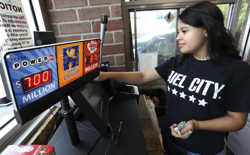 Anahi Medrano sells a Powerball lottery ticket at a convenience store in Dallas Wednesday, Aug. 23, 2017. Lottery officials said the grand prize for Wednesday night's drawing has reached $700 million. The second -largest on record for any U.S. lottery game. (AP Photo/LM Otero)