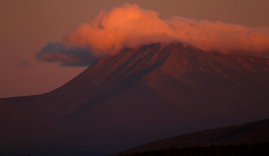 In this Monday, Aug. 7, 2017 photo, the first rays of sunlight color the clouds over Mount Katahdin in this view from the Katahdin Woods and Waters Scenic Byway outside Patten, Maine. Interior Secretary Ryan Zinke wants to retain the newly created Katahdin Woods and Waters National Monument in northern Maine, but said he might recommend adjustments to the White House on Thursday, Aug. 24, 2017. (AP Photo/Robert F. Bukaty)