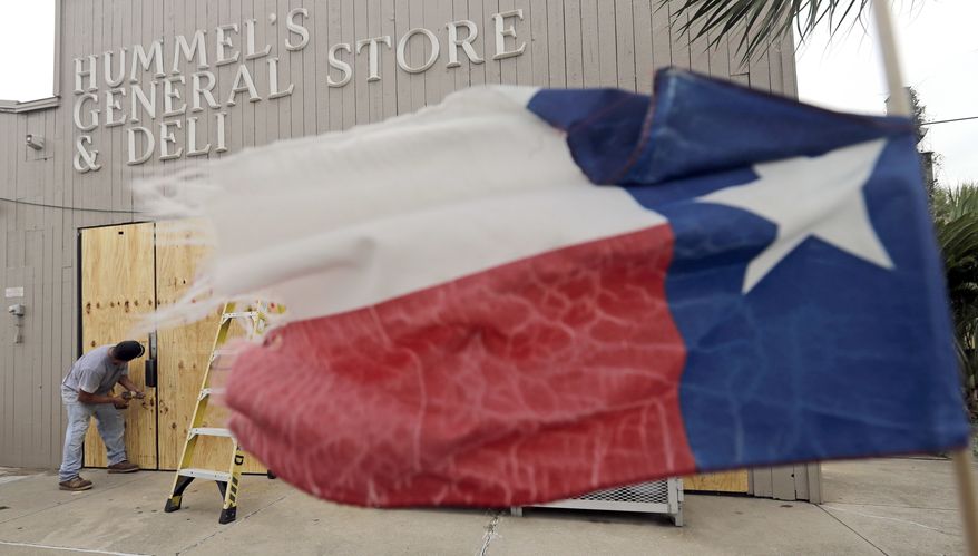 Ramon Lopez boards up windows of a business in Galveston, Texas as Hurricane Harvey intensifies in the Gulf of Mexico Friday, Aug. 25, 2017. Harvey is forecast to be a major hurricane when it makes landfall along the middle Texas coastline. (AP Photo/David J. Phillip)
