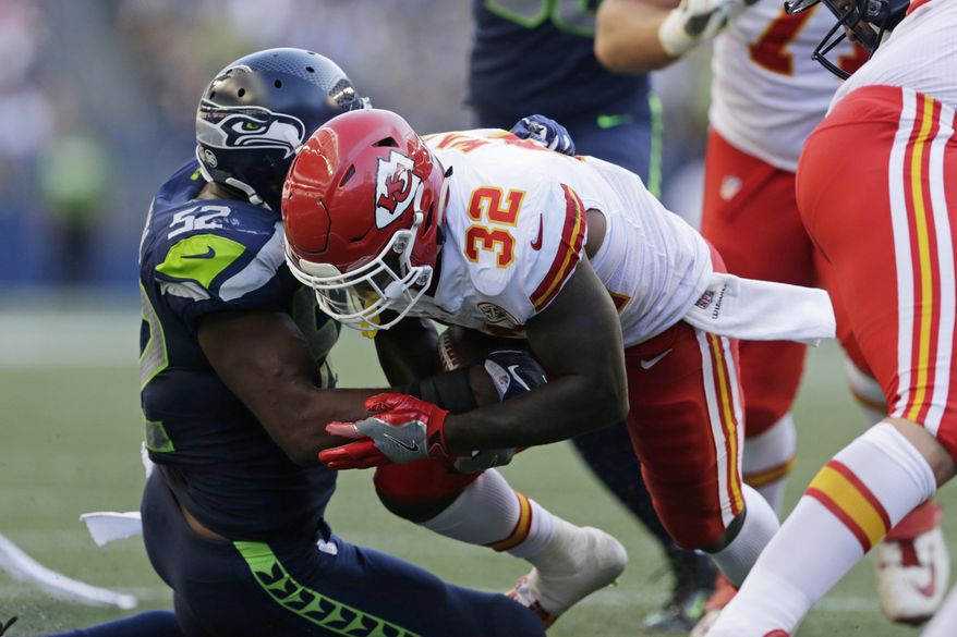 Kansas City Chiefs running back Spencer Ware is tackled by Seattle Seahawks linebacker Terence Garvin (52) during the first half of an NFL football preseason game, Friday, Aug. 25, 2017, in Seattle. Ware left the field with an injury after the play. (AP Photo/John Froschauer)