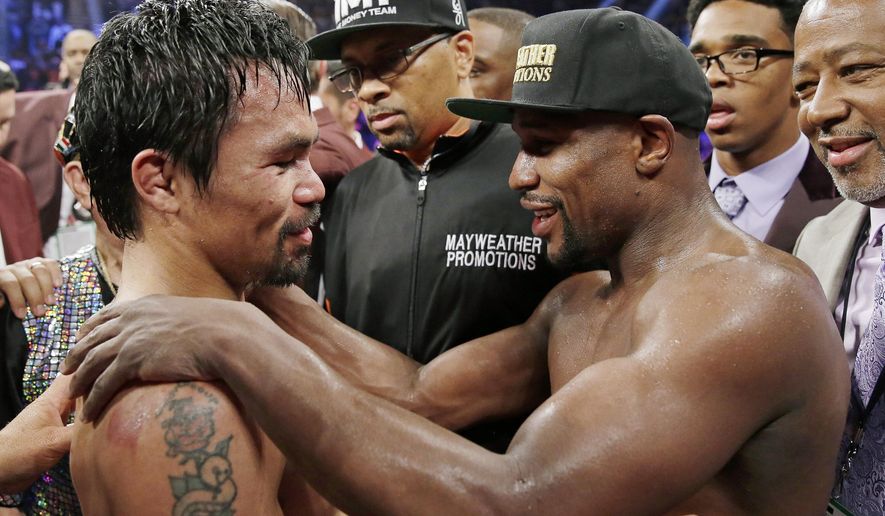 FILE - This May 2, 2015 file photo shows Manny Pacquiao from the Philippines, left, and Floyd Mayweather Jr., embracing in the ring at the finish of their welterweight title fight in Las Vegas. A federal judge Friday, Aug. 25, 2017 dismissed class-action lawsuits by disgruntled boxing fans around the country who complained they didn't get their pay-per-view money's worth in the fight. The judge said that he felt sympathy for fans who felt deceived that Pacquiao's camp failed to disclose he had a shoulder injury until about three hours before the fight. (AP Photo/Isaac Brekken,File)