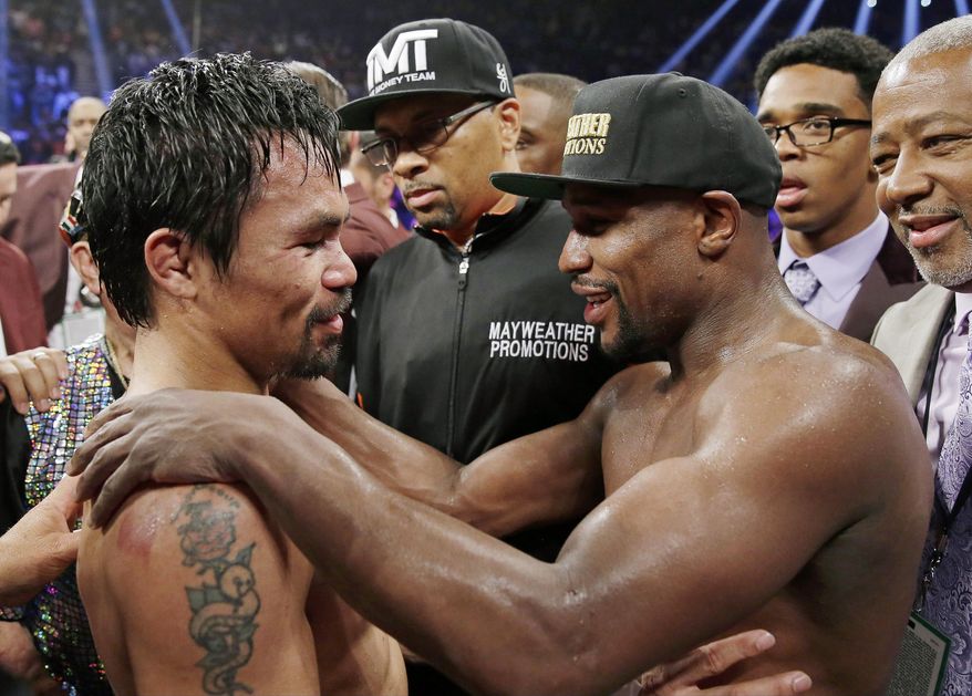 FILE - This May 2, 2015 file photo shows Manny Pacquiao from the Philippines, left, and Floyd Mayweather Jr., embracing in the ring at the finish of their welterweight title fight in Las Vegas. A federal judge Friday, Aug. 25, 2017 dismissed class-action lawsuits by disgruntled boxing fans around the country who complained they didn't get their pay-per-view money's worth in the fight. The judge said that he felt sympathy for fans who felt deceived that Pacquiao's camp failed to disclose he had a shoulder injury until about three hours before the fight. (AP Photo/Isaac Brekken,File)