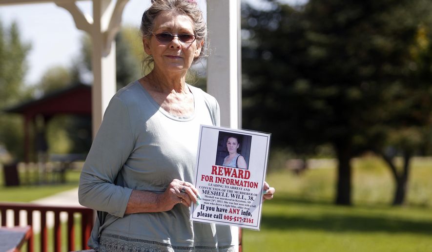 In this Aug. 22. 2017, photo Nancy Herman, of Custer S.D., holds a reward poster for information about the death of her friend Meshell Will. Herman has put up posters, saved money for a reward and created a Facebook page to gather information about Will’s suspicious death. (Chris Huber/Rapid City Journal via AP)