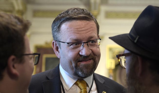 In this Tuesday, May 2, 2017, file photo, Sebastian Gorka, then-deputy assistant to President Donald Trump, talks with people in the Treaty Room in the Eisenhower Executive Office Building on the White House complex in Washington during a ceremony commemorating Israeli Independence Day. Gorka tells The Associated Press he has resigned from his position, Friday, Aug. 25, 2017. (AP Photo/Susan Walsh, File)
