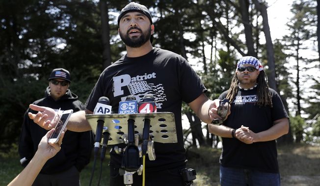 Joey Gibson of the group Patriot Prayer, center, speaks at a news conference in Pacifica, Calif, Saturday, Aug. 26, 2017. Officials took steps to prevent violence ahead of a planned news conference by a right-wing group. (AP Photo/Marcio Jose Sanchez)
