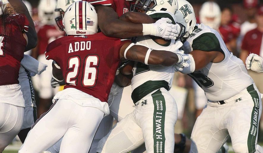 Massachusetts' Ali Ali-Musa, top, and Jerall Addo (26) take down Hawaii's Mykal Tolliver during the first quarter of an NCAA college football game Saturday, Aug. 26, 2017, in Amherst, Mass. (J. Anthony Roberts/The Republican via AP)