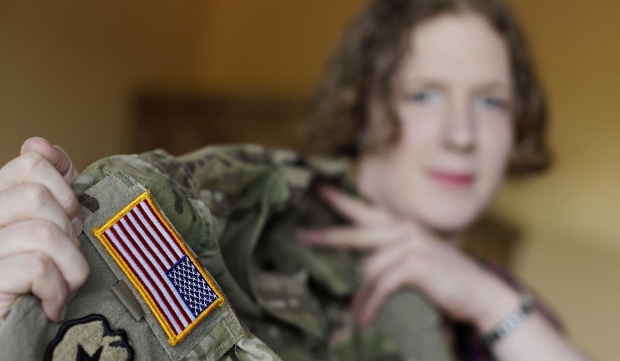 In this July 29, 2017, file photo transgender U.S. Army Capt. Jennifer Sims lifts her uniform during an interview with The Associated Press in Beratzhausen near Regensburg, Germany. (AP Photo/Matthias Schrader) ** FILE **
