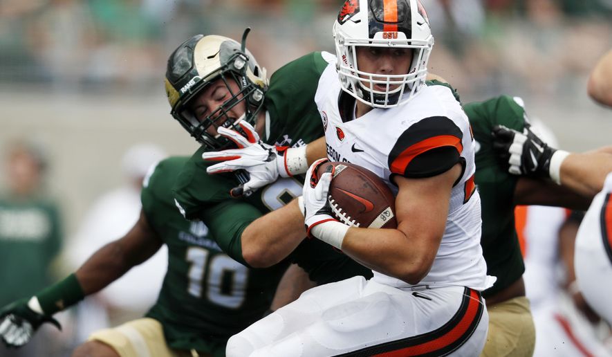 Oregon State running back Ryan Nall, front, looks for an opening as Colorado State defensive lineman Jakob Buys comes in for a stop in the first half of an NCAA college football game Saturday, Aug. 26, 2017, in Fort Collins, Colo. (AP Photo/David Zalubowski)