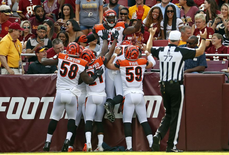 Cincinnati Bengals outside linebacker Vontaze Burfict, top, celebrates with teammates after intercepting a pass by Washington Redskins quarterback Kirk Cousins and scoring a touchdown in the first half of a preseason NFL football game, Sunday, Aug. 27, 2017, in Landover, Md. (AP Photo/Alex Brandon)