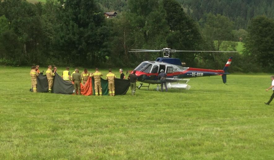 Rescue workers stand next to a police helicopter in Krimml in the Austrian province of Salzburg, Sunday, Aug. 27, 2017. The Austrian Red Cross said five mountain climbers died Sunday in the Austrian Alps in Wildgerlostal on Mount Gabler, east of Innsbruck, and a sixth climber was severely injured, the Austrian news agency APA reported. (AP Photo/Franz Brinek)