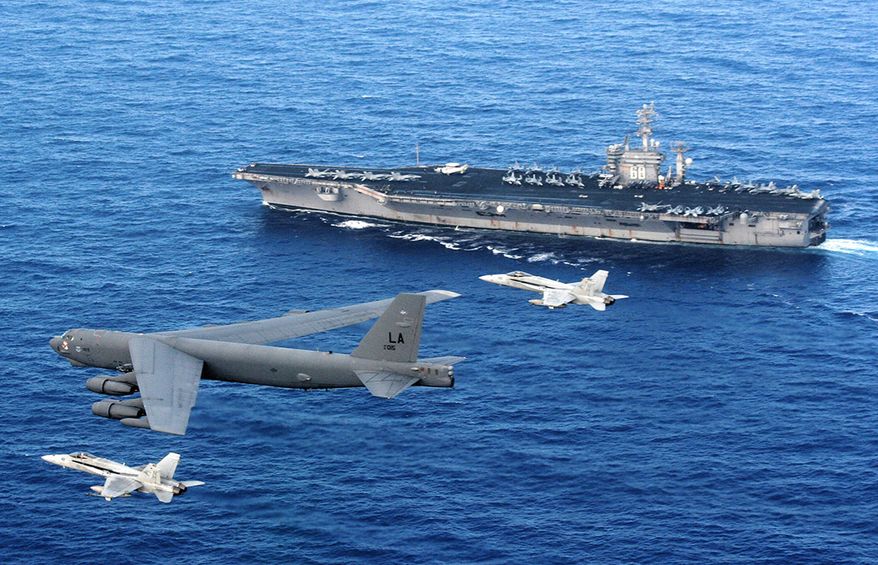 A B-52 Stratofortress flies past the USS Nimitz as two U.S. Navy F/A-18 Hornets intercept. The B-52 is from the 96th Expeditionary Bomb Squadron deployed to Andersen Air Force Base, Guam. (U.S. Navy photo)