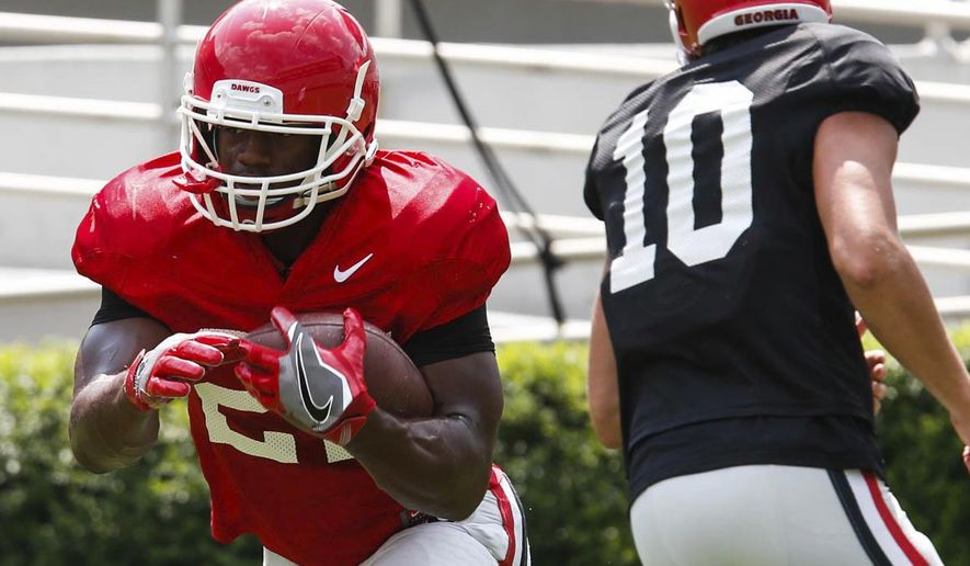 FILE - In this Aug. 5, 2017, file photo, Georgia tailback Nick Chubb (27) takes a hand off from quarterback Jacob Eason (10) during practice in Athens, Ga. For No. 15 Georgia to make a move up the SEC standings in Kirby Smart's second season as coach, the Bulldogs must make a move up from their poor 2016 ranking as the 11th-best scoring offense in the league. (Joshua L. Jones/Athens Banner-Herald via AP, File)
