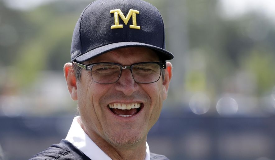 This July 17, 2017 photo shows Michigan football coach Jim Harbaugh in Ann Arbor, Mich. It's game week for Michigan, and Harbaugh is playing games of another kind — keeping his roster secret. He also won’t say whether returning starter Wilton Speight or seldom-used senior John O’Korn will take the first snap for the 11th-ranked Wolverines against No. 17 Florida in Texas in the opener for both schools. (AP Photo/Carlos Osorio)