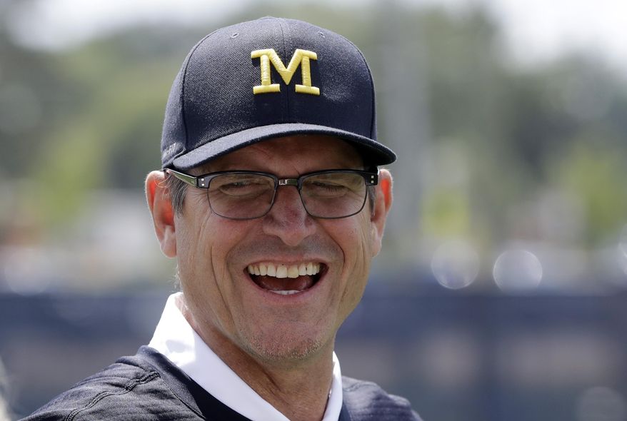This July 17, 2017 photo shows Michigan football coach Jim Harbaugh in Ann Arbor, Mich. It's game week for Michigan, and Harbaugh is playing games of another kind — keeping his roster secret. He also won’t say whether returning starter Wilton Speight or seldom-used senior John O’Korn will take the first snap for the 11th-ranked Wolverines against No. 17 Florida in Texas in the opener for both schools. (AP Photo/Carlos Osorio)