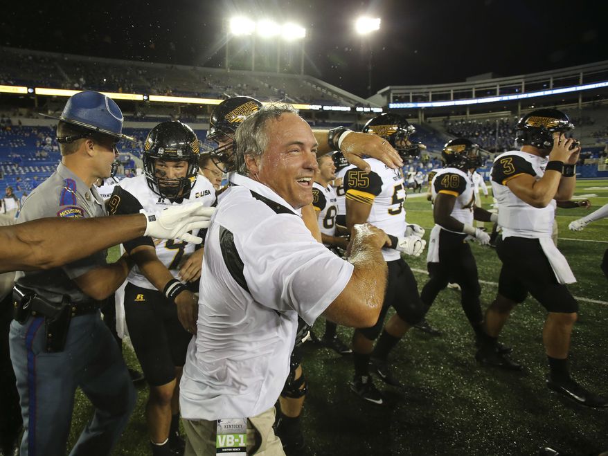 FILE - In this Sept. 3, 2016, file photo, Southern Mississippi head coach Jay Hopson, center, celebrates with his team after defeating Kentucky in an NCAA college football game, in Lexington, Ky. Southern Miss rallied for a stunning 44-35 win over Kentucky last year in Lexington. Now the Golden Eagles get a chance to make it two in a row _ and this time the game's at home in Roberts Stadium.(AP Photo/David Stephenson, File)