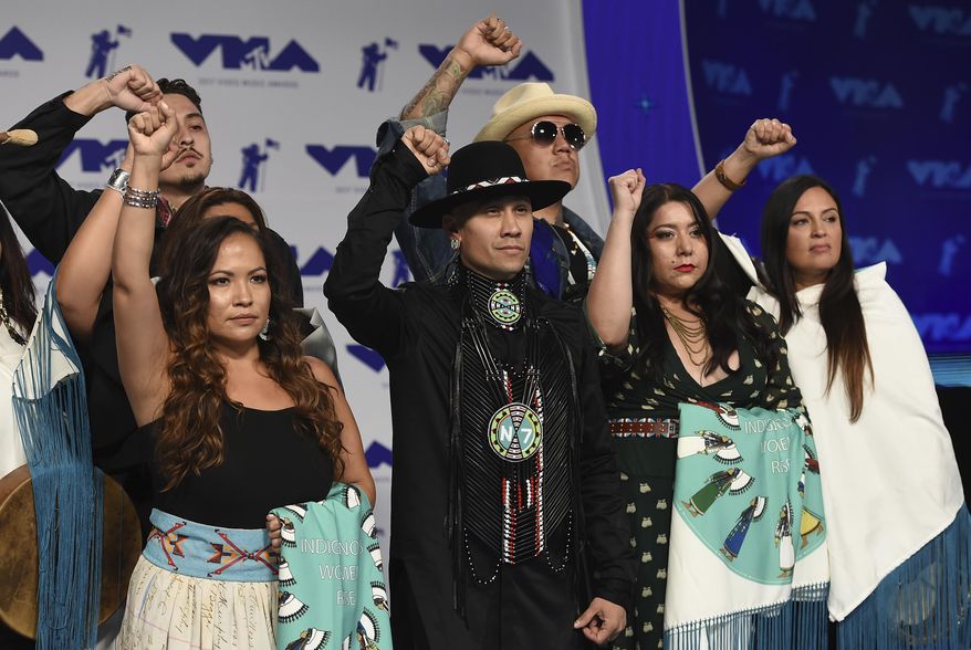 Taboo, center, and Native American musicians raise their fists in protest of the Dakota Access Pipeline as they arrive at the MTV Video Music Awards at The Forum on Sunday, Aug. 27, 2017, in Inglewood, Calif. (Photo by Jordan Strauss/Invision/AP)