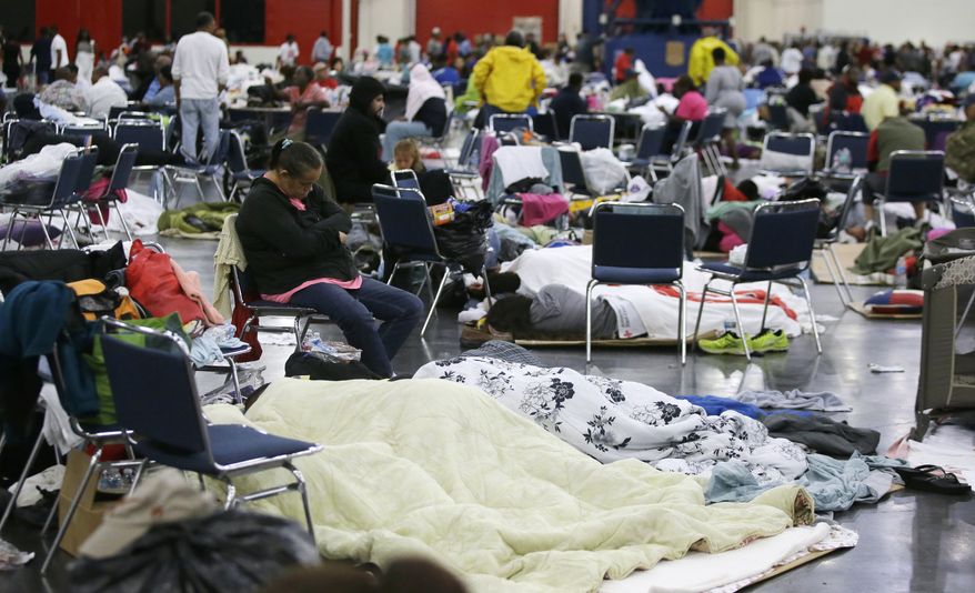 People rest at the George R. Brown Convention Center that has been set up as a shelter for evacuees escaping the floodwaters from Tropical Storm Harvey in Houston, Texas, Tuesday, Aug. 29, 2017. (AP Photo/LM Otero)