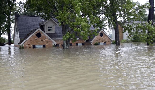 A home is surrounded by floodwaters from Tropical Storm Harvey on Monday, Aug. 28, 2017, in Spring, Texas. Homeowners suffering from Harvey flood damage are more likely to be on the hook for losses than victims of prior storms, a potentially crushing blow to personal finances and neighborhoods along the Gulf Coast. Experts say far too few homeowners have flood insurance, just two of ten living in Harvey’s path of destruction. (AP Photo/David J. Phillip)
