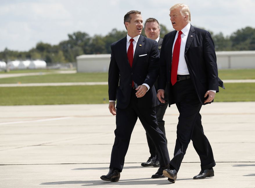 Missouri Gov. Eric Greitens, left, walks with President Donald Trump as they arrive in Springfield, Mo., Wednesday, Aug. 30, 2017. (AP Photo/Alex Brandon)