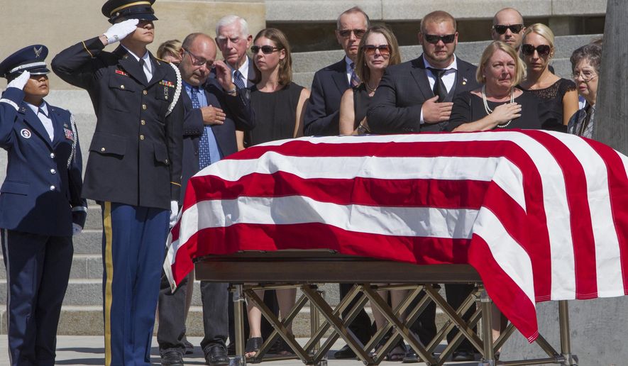 Family members watch as former Idaho Gov. Cecil Andrus' casket arrives at the Capitol building where he will lie in state Wednesday, Aug. 30, 2017 in Boise. Andrus, who died last week, also served as secretary of the Interior in the Carter administration. (Darin Oswald/Idaho Statesman via AP)