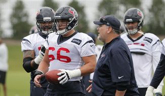 Houston Texans center Nick Martin (66) along with other lineman takes instructions from offensive line coach Mike Devlin, right front, during a morning practice at the Dallas Cowboys training facility, Monday, Aug. 28, 2017, in Frisco, Texas. The Texans are working out in the practice facility of the Dallas Cowboys because of floods pounding Houston. An exhibition game in the Texans&#39; stadium Thursday might be moved to the home of the Cowboys.  (AP Photo/Tony Gutierrez) **FILE**