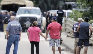 Family members hold hands as recovery efforts were underway for a van with 6 family whose bodies were were found in a van at Greens Bayou in east Houston, after Tropical Storm Harvey left the Houston area on Wednesday, Aug. 30, 2017, in Houston. ( Elizabeth Conley/Houston Chronicle via AP)
