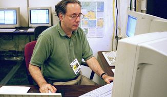 In this July 28, 1996 photo, Associated Press senior photo editor Michael Feldman works at the Summer Olympics in Atlanta. Feldman, a veteran wire service photographer and editor whose 40-year career took him from the gritty streets of Philadelphia to major international sporting events like the Olympics and soccer’s World Cup, has died. He was 70. (AP Photo/Chuck Zoeller)