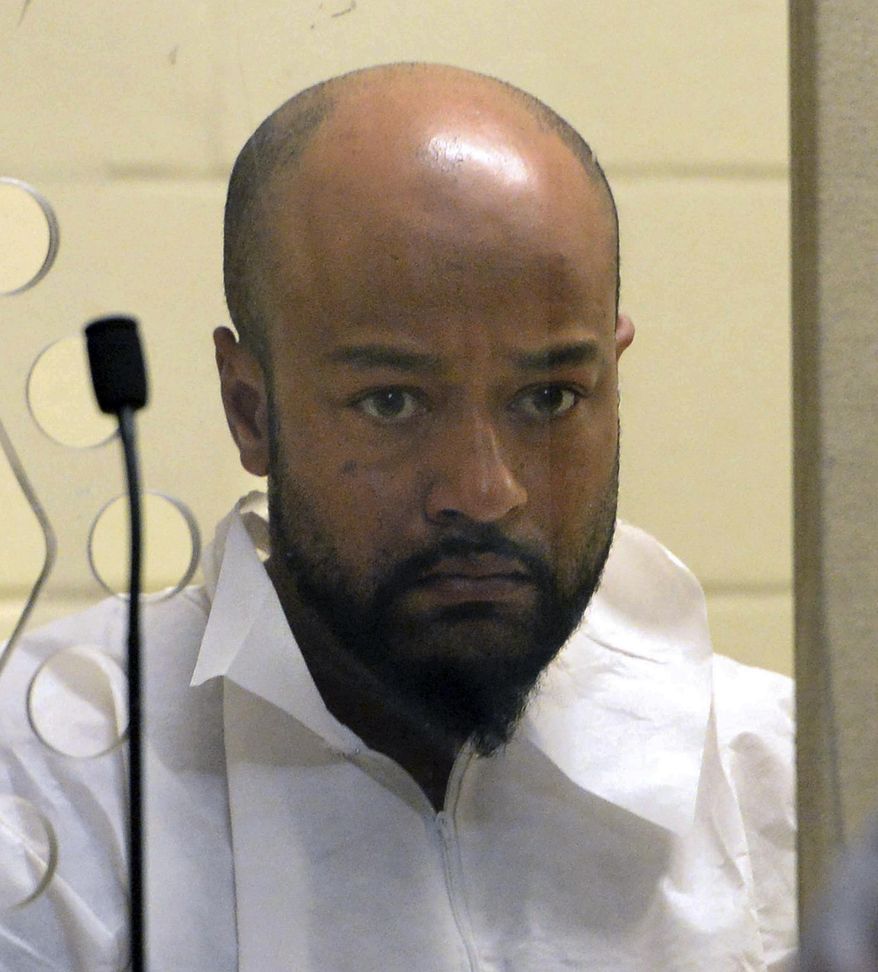 Daniel J. Lopes peers out from the defendant's box during his murder arraignment in Brockton District Court on Wednesday, Aug. 30, 2017. Lopes is charged in the murder of Julia Fernandes, 72, of West Bridgewater. (Marc Vasconcellos/The Enterprise via AP, Pool)