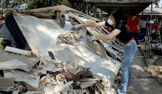 Lucy Liu helped her co-worker Tianna Oliver clean out her flood-damaged house on Thursday. Government agencies also have kicked into high gear as the Houston region begins to recover from Hurricane Harvey. (Associated Press)