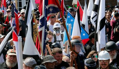 In this Saturday, Aug. 12, 2017, file photo, white nationalist demonstrators walk into the entrance of Lee Park surrounded by counter demonstrators in Charlottesville, Va. (AP Photo/Steve Helber) ** FILE **