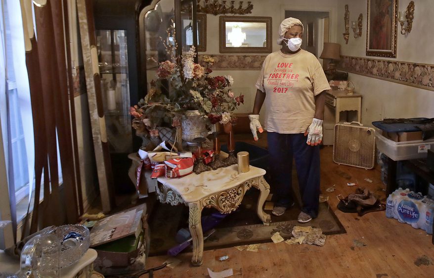 Lois Rose looks over belongings while salvaging items from his flood-damaged house Thursday, Aug. 31, 2017, in Houston. The city continues to recover from record flooding caused by Hurricane Harvey. (AP Photo/Charlie Riedel)