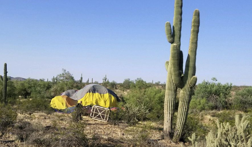 This Thursday, Aug. 31, 2017, photo provided by the Peoria Fire Department shows a downed hot air balloon that had apparently clipped a power line discovered by fire crews in the desert of Peoria, Ariz. Authorities say initial reports indicate three people were on board the balloon when it crashed Thursday morning and that the balloon's occupants were picked up by a vehicle following the balloon. (Rob Brewster/Peoria Fire Department via AP)