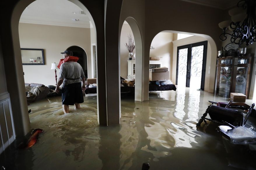 Mike Stamps stands in his home in the Kingwood Greens Subdivision flooded from the San Jacinto River due to Tropical Storm Harvey, Wednesday, Aug. 30, 2017, in Kingwood, Texas. Stamps was there to retrieve his two cats , who had to be left behind, as he was evacuated on a jet ski Tuesday. (Karen Warren/Houston Chronicle via AP)