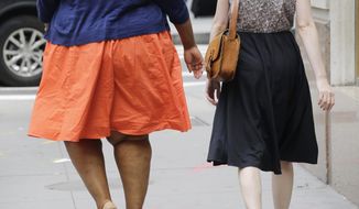 In this Monday, July 13, 2015 photo, an obese woman, left, walks in New York. A federal study published on June 19, 2018, shows that rural Americans are more likely to be obese than those living in urban areas. (AP Photo/Mark Lennihan) **FILE**